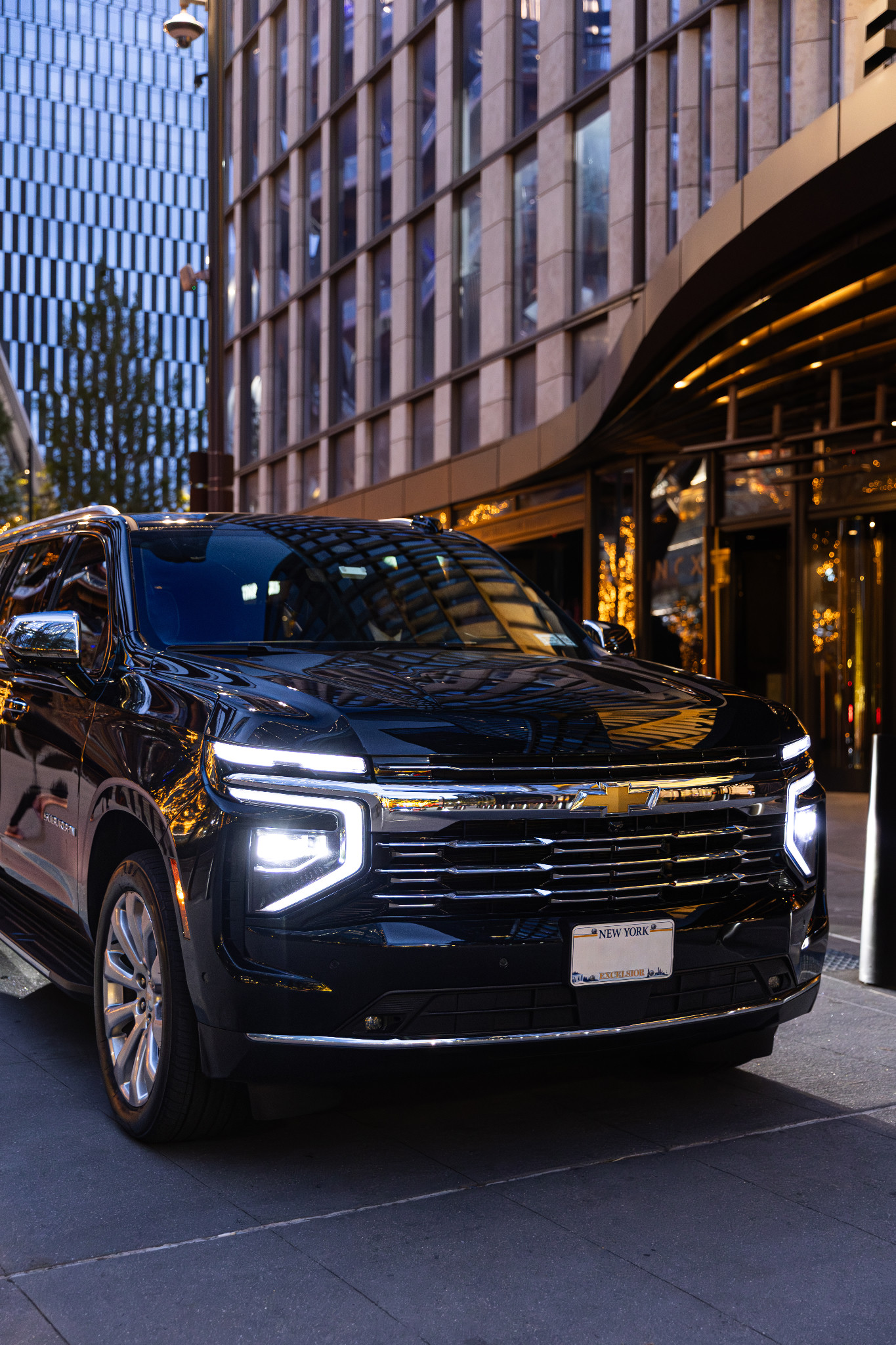 Black Chevrolet Suburban outside an illuminated building